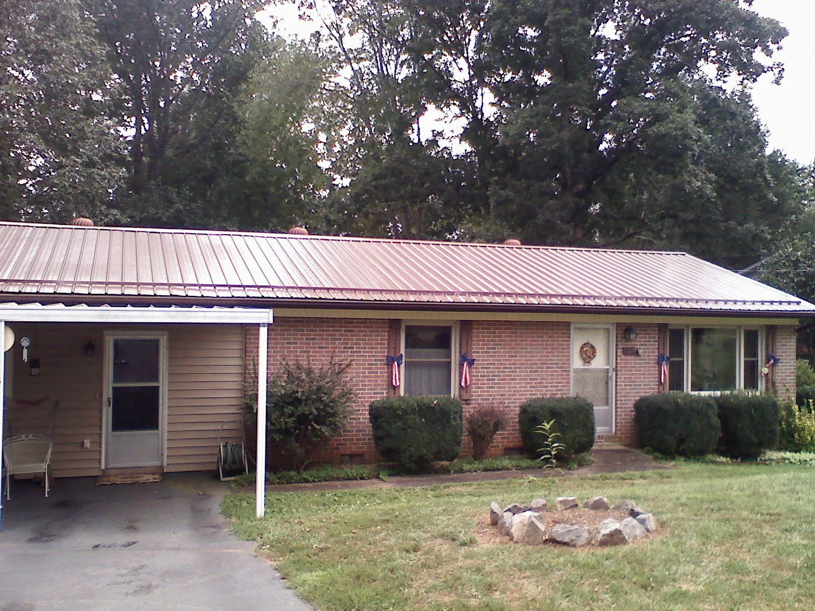 Bronze metal roof and carport on a brick ranch home — Roof Repair work by our crew in Ewing